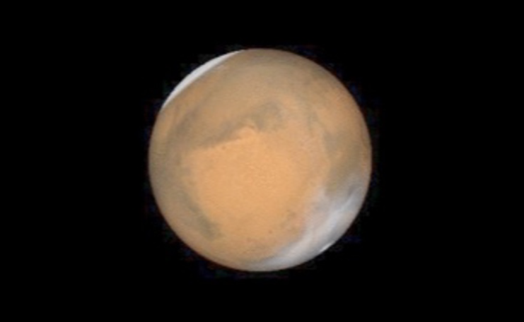 Telescope image of Mars with the polar ice caps visible.